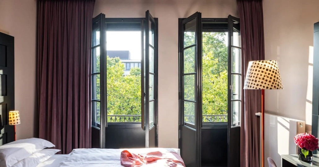 the-midtown-hotel-zimmer-medium-double-2 Hotelzimmer mit offenem Fenster und Blick ins Grüne.